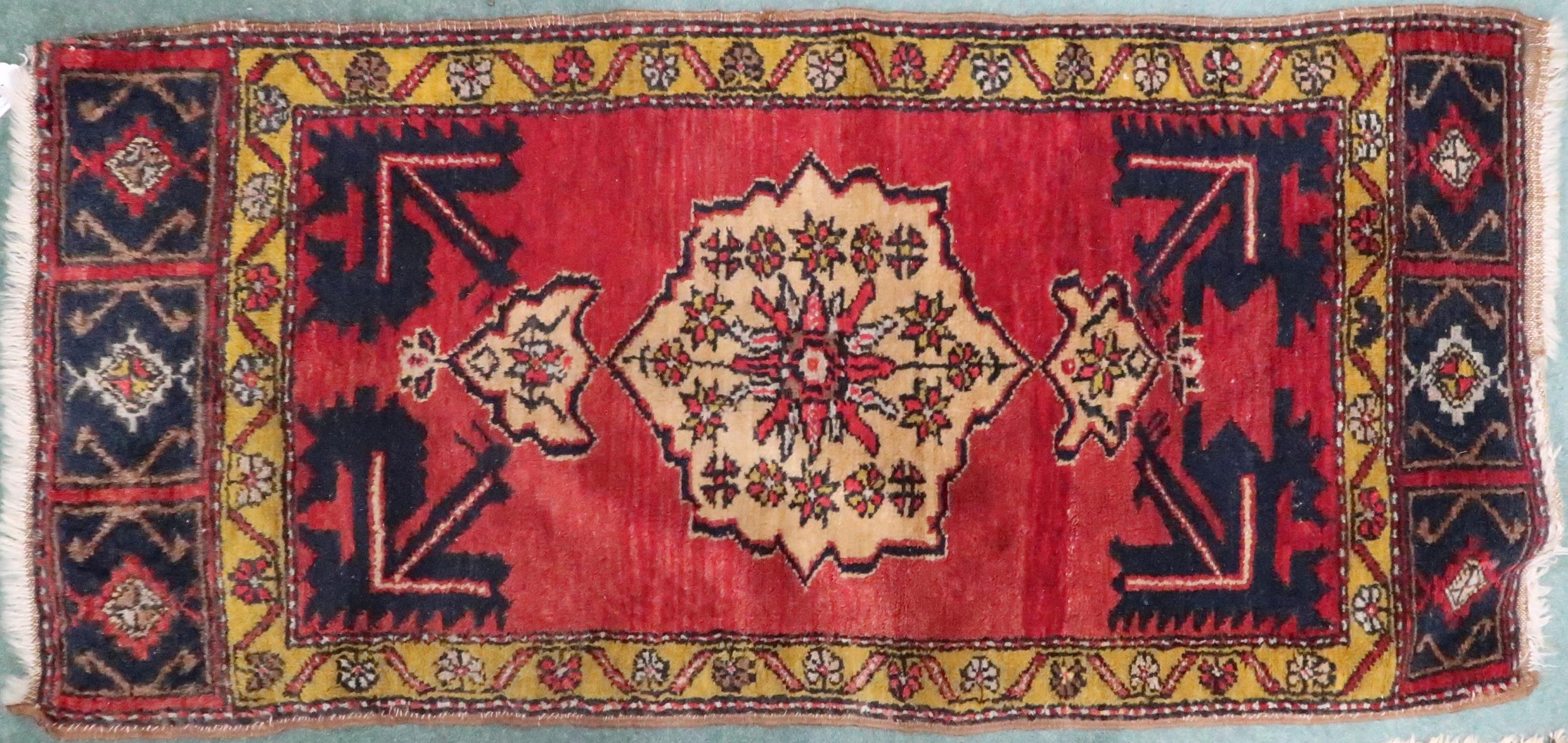 A pink ground Persian rug with cream central medallion, dark blue spandrels and mustard border,