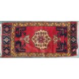 A pink ground Persian rug with cream central medallion, dark blue spandrels and mustard border,
