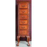 A 20th century mahogany tall boy chest with six drawers flanked by carved reliefs on ball and claw