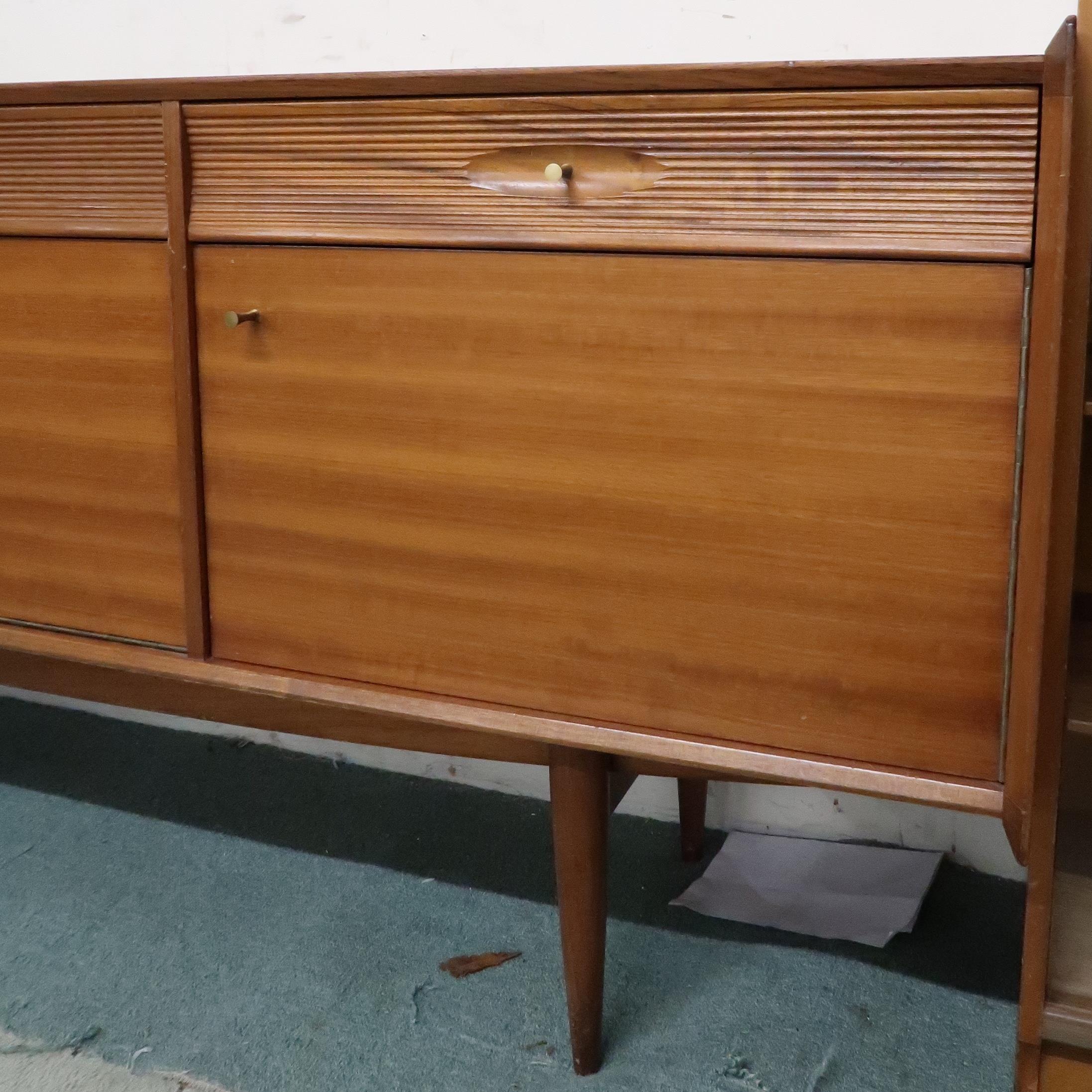 A mid 20th century teak sideboard with three drawers over central fall front compartment flanked - Image 2 of 8