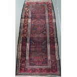 A dark ground Baluch runner with four geometric medallions and multiple borders, 296cm long x