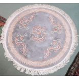 A pale blue ground Oriental style circular rug with dragon motifs and key design border, 161cm