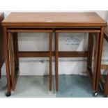 A mid 20th century teak McIntosh of Kirkcaldy nest of tables with fold over top over pair of