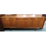 A mid 20th century teak McIntosh concave sideboard with three drawers with shaped handles over