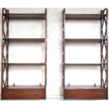 A pair of 20th century mahogany open wall shelves with four shelves flanked by decorative pierced