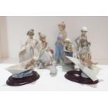 A collection of Lladro figures of children and two of puppies, one in a paper boat, the other a
