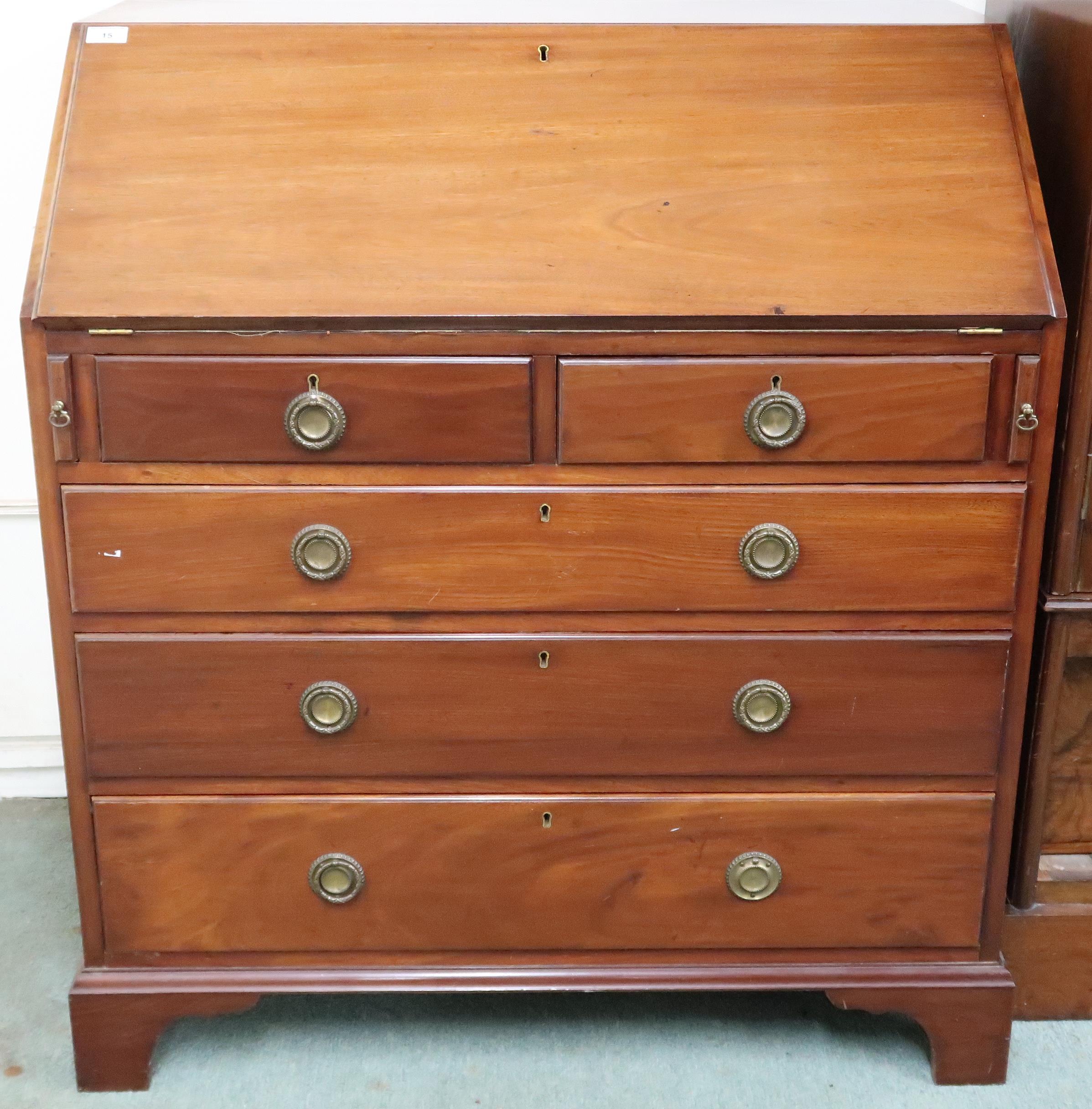 An early 20th century mahogany bureau with fitted fall front writing compartment over two short over