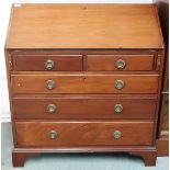 An early 20th century mahogany bureau with fitted fall front writing compartment over two short over
