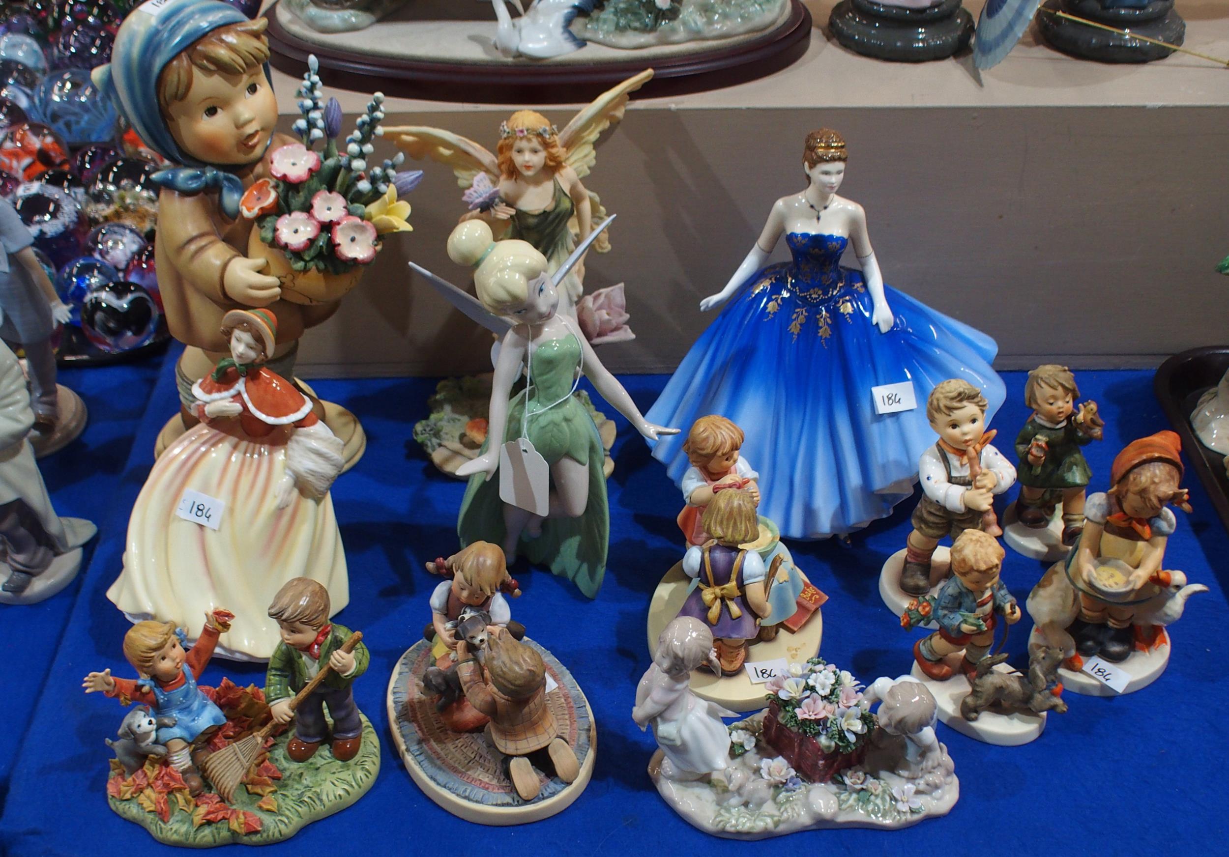 A large resin Hummel figure, three others smaller, porcelain Hummels including Sunday Stroll, two