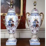 A pair of 20th century ceramic based table lamps with floral decoration around armorial crest (2)