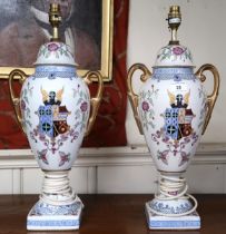 A pair of 20th century ceramic based table lamps with floral decoration around armorial crest (2)