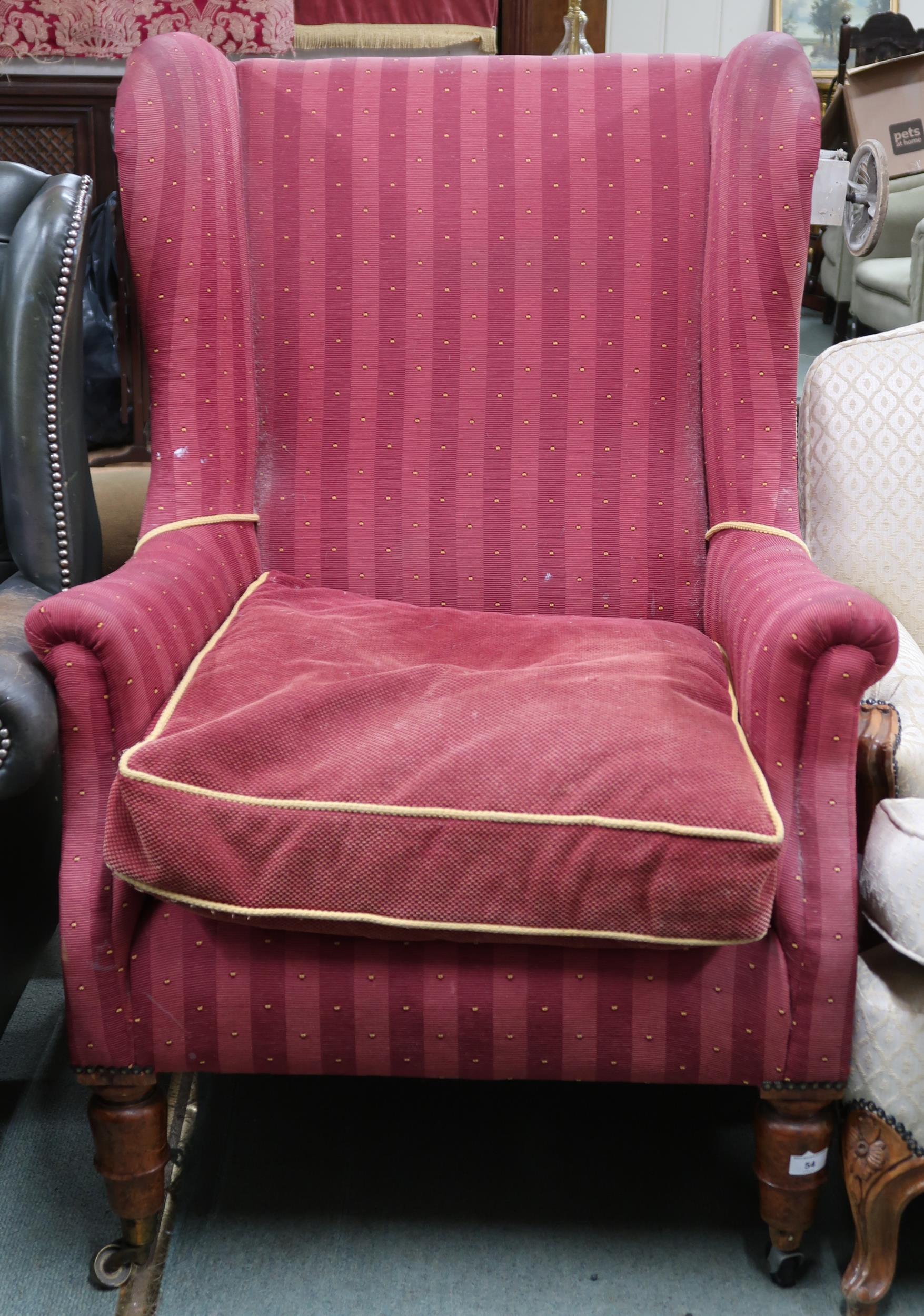 A Victorian wing back armchair with red striped upholstery on turned front supports, 110cm high x