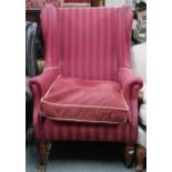 A Victorian wing back armchair with red striped upholstery on turned front supports, 110cm high x