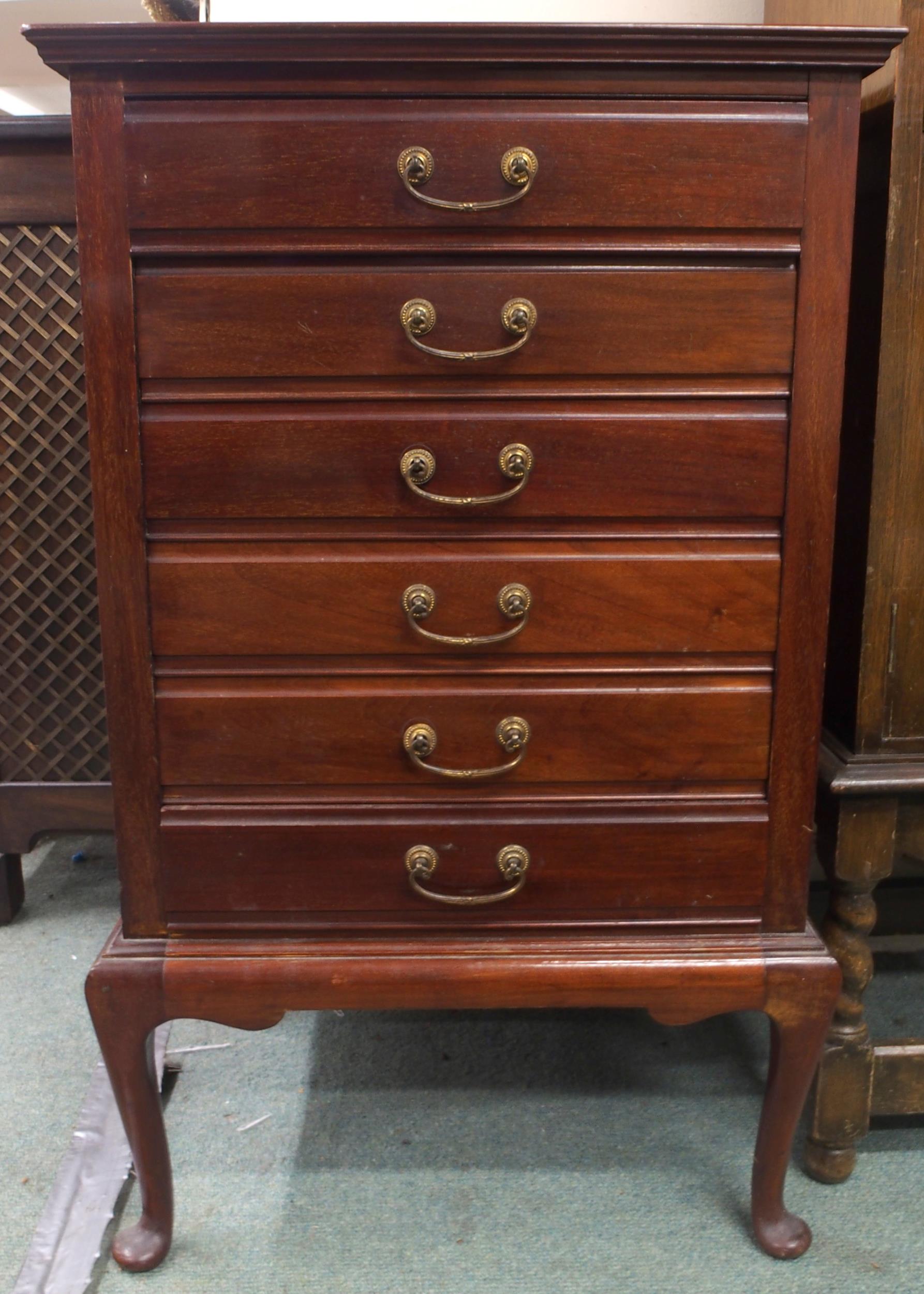 An Edwardian mahogany music cabinet with six drawers with hinged front facings on cabriole supports,