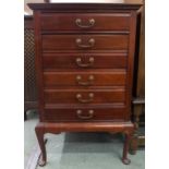 An Edwardian mahogany music cabinet with six drawers with hinged front facings on cabriole supports,