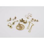 A collection of 9ct gold items to include a retro Aquarius pendant and seven pairs of earrings,