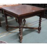 An early 20th century oak pull out dining table on turned barley twist supports joined by crossed