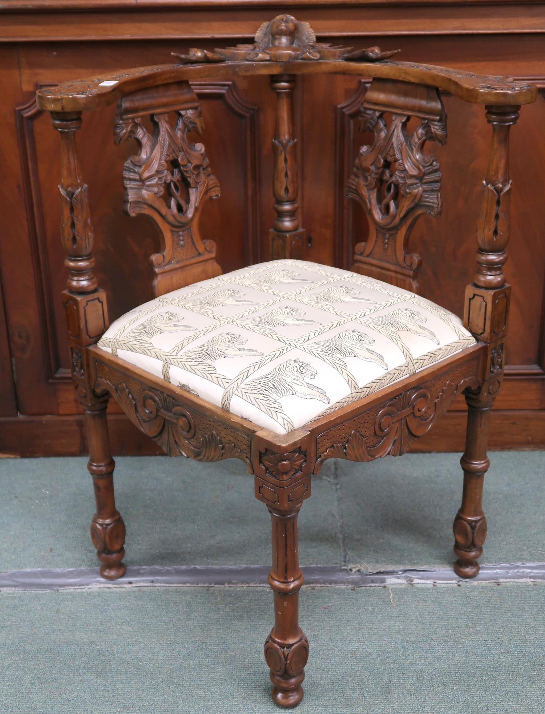 A 20th century walnut corner chair with shaped back over carved pierced splats joined to seat with