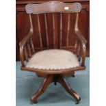 An early 20th century elm rail back swivel desk chair with shaped arms over leather upholstered seat