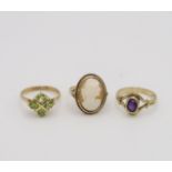 A 9ct ring set with four peridot, size N, a 9ct amethyst ring size M1/2, and a 9ct gold  cameo ring,