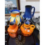Two West German orange glazed vases, a blue vase, a Clarice Cliff style jug and a glass figural