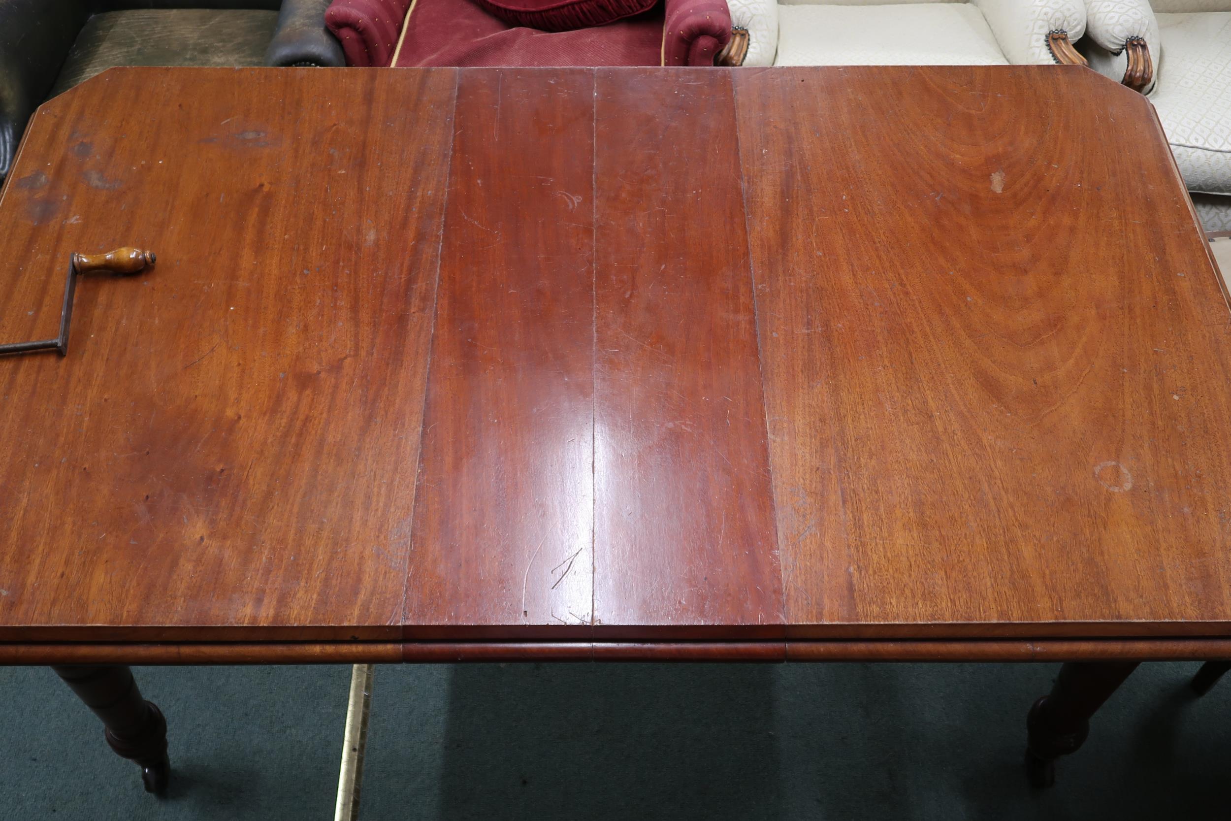 A Victorian mahogany wind out extending dining table on turned supports terminating in ceramic - Image 2 of 7