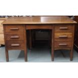 An early 20th century oak clerks desk with sloped writing top over single central drawer flanked