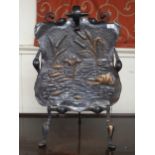An early 20th century copper and wrought iron Art Nouveau fire screen embossed with a river scene,