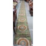 A green ground Axminster style stair runner, 1162cm long x 70cm wide  Condition Report:Available