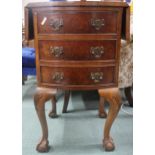 A 20th century walnut veneered bow fronted three drawer chest on ball and claw supports, 74cm high x