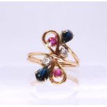 A bright yellow metal dress ring stamped 18, set with diamonds, rubies and sapphires, size O, weight