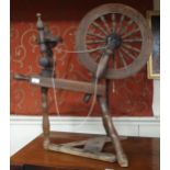 A 19th century elm treadle spinning wheel, 84cm high Condition Report:Available upon request