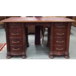 A 20th century mahogany twin pedestal desk with red skivered top over central single drawer