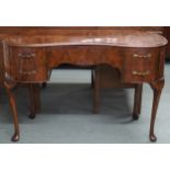 A 20th century kidney shaped dressing table with central frieze drawer flanked by two drawers either