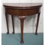 An early 20th century mahogany demilune fold-over tea table on shaped supports, 70cm high x 78cm