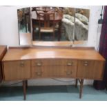 A mid 20th century teak concave front dressing table on turned tapering supports, 128cm high x 132cm