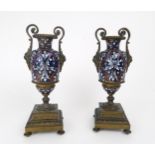 A PAIR OF FRENCH CHAMPLEVE ENAMEL AND GILDED METAL GARNITURE URNS each with lions head scroll