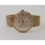 A 9CT GOLD GENTS LONGINES WATCH with integral woven strap, a silvered dial, gold baton numerals