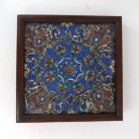 A PERSIAN POLYCHROME TILE Relief moulded and painted with flowers and scrolling foliage in green and