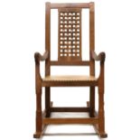 A PETER "RABBITMAN" HEAP OAK LATTICE BACK ROCKING CHAIR with carved lattice splat over beige leather