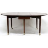 A VICTORIAN MAHOGANY DROPLEAF TABLE  with oval drop leaf top on square tapering supports terminating