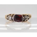 A GEORGIAN STYLE RING mounted in yellow metal set with a red gem and rose cut diamonds, finger