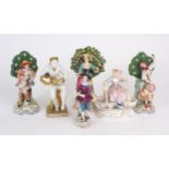 A PAIR OF CHELSEA STYLE FIGURES each with flowering bocage backgrounds, another similar figure, a