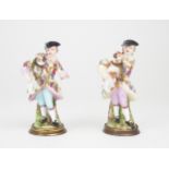 A PAIR OF CONTINENTAL, PROBABLY GERMAN PORCELAIN PERFUME BOTTLES each modelled as a man holding a