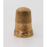 A YELLOW METAL THIMBLE from the Cranston family estate, engraved 'M. Cranston' with a flower