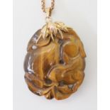 A CHINESE PENDANT CARVED WITH A RABBIT carved in tiger's eye the rabbit is depicted with pumpkins,