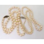 TWO STRINGS OF PEARLS WITH DECORATIVE CLASPS the smaller strand, the pearls taper in size from 7mm