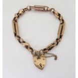 A 9CT FANCY LINK BRACELET with heart shaped clasp and alternate twisted and baton links, with