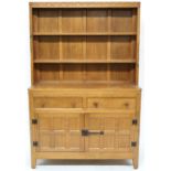 A PETER "RABBITMAN" HEAP OAK KITCHEN DRESSER with cornice carved with key design over two open plate
