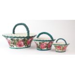THREE WEMYSS GRADUATED BASKETS each of oval form and painted with cabbage roses, with green rope